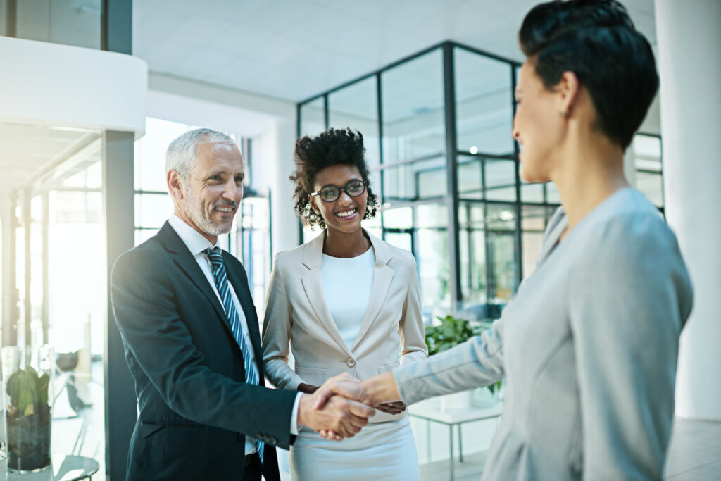 A professional handshake in a modern office, capturing the trust and connection behind successful client acquisition.